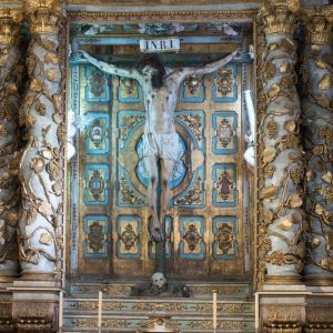 Retablo barroco con la imagen del Cristo de Burgos en la Catedral de Santiago. Columnas salomónicas doradas y talla de Cristo con faldón de tela.