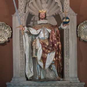 Escultura barroca de San Fernando en la Catedral de Santiago. Talla policromada con espada y orbe en un retablo con veneras y decoración pétrea.