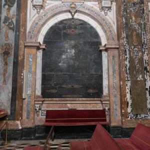 Lápida de mármol negro del arzobispo Monroy en la Capilla del Pilar, Catedral de Santiago. Inscripción funeraria y escudo heráldico barroco.