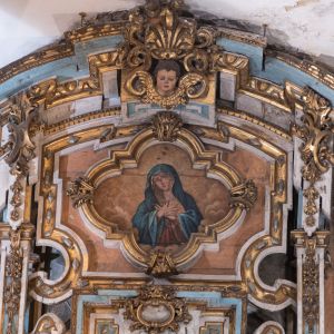 Coronamiento del retablo barroco de la Capilla de San Antonio, con pintura de la Dolorosa enmarcada en molduras doradas.