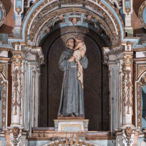 Cuerpo superior del retablo barroco de la Capilla de San Antonio, con la imagen titular del santo sosteniendo al Niño Jesús.
