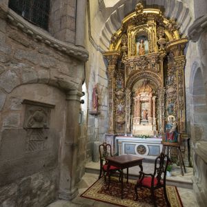 Vista general de la Capilla de San Juan en la Catedral de Santiago de Compostela. Retablo barroco dorado y arquitectura románica en granito.
