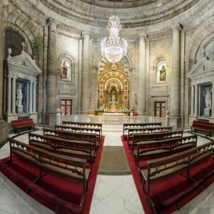 Interior neoclásico de la Capilla de la Comunión en la Catedral de Santiago con planta de rotonda, columnas de granito y retablo dorado.