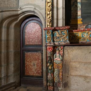 Puerta a la sacristía de la Capilla de Mondragón con arco de piedra y decoración tallada y policromada renacentista.