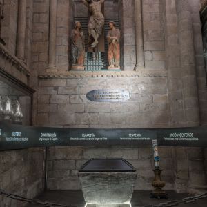 Baptisterio de la Catedral de Santiago con pila bautismal y calvario gótico de Cristo, María y San Juan.