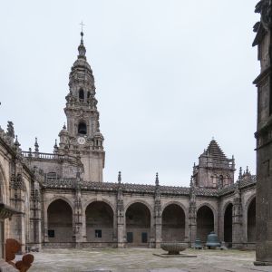 Vista del claustro catedralicio de Santiago de Compostela con la Torre del Reloj barroca al fondo y la Fons Mirabilis en el centro del patio.