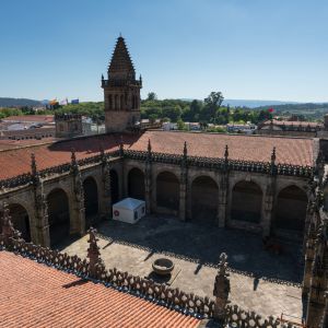 Vista aérea del claustro de la Catedral de Santiago de Compostela desde los tejados, con crestería gótica, arcadas y patio central.