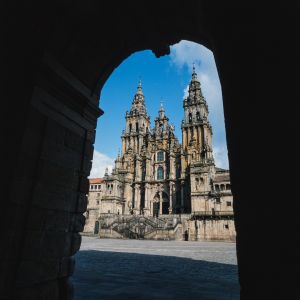 Vista de la Fachada del Obradoiro de la Catedral de Santiago encuadrada desde los soportales del Palacio de Raxoi. Arquitectura barroca en piedra.