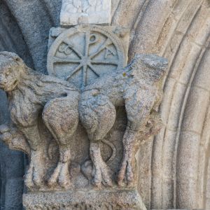Esculturas románicas de figuras entrelazadas en la unión de los arcos de la fachada de las Platerías