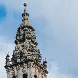 Detalle del remate barroco de la Torre de las Campanas con sus características bellotas y pináculos de granito labrado contra el cielo.