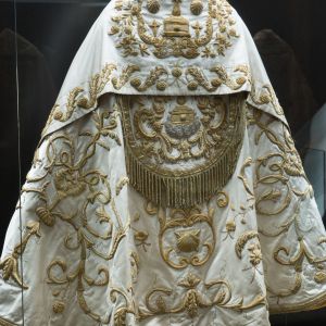 Capa pluvial de seda y oro (S. XVIII) de Acuña y Malvar. Detalle de bordados neoclásicos y veneras en el Museo de la Catedral de Santiago.