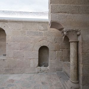 Columna románica con capitel de volutas y alacenas bajo arco de medio punto en la cocina del Palacio de Gelmírez, Santiago de Compostela
