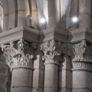 Capiteles románicos de la Cripta del Pórtico de la Gloria (S. XII). Detalle de escultura en granito con motivos vegetales y figuras humanas. Catedral 