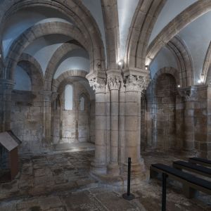Pilar central de la Cripta del Pórtico de la Gloria que sostiene el parteluz superior. Vista de la girola y arquitectura románica del Maestro Mateo.