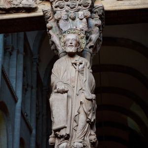 Santiago Apóstol en el parteluz del Pórtico de la Gloria con báculo en tau y capitel de las Tentaciones de Cristo. Catedral de Santiago.